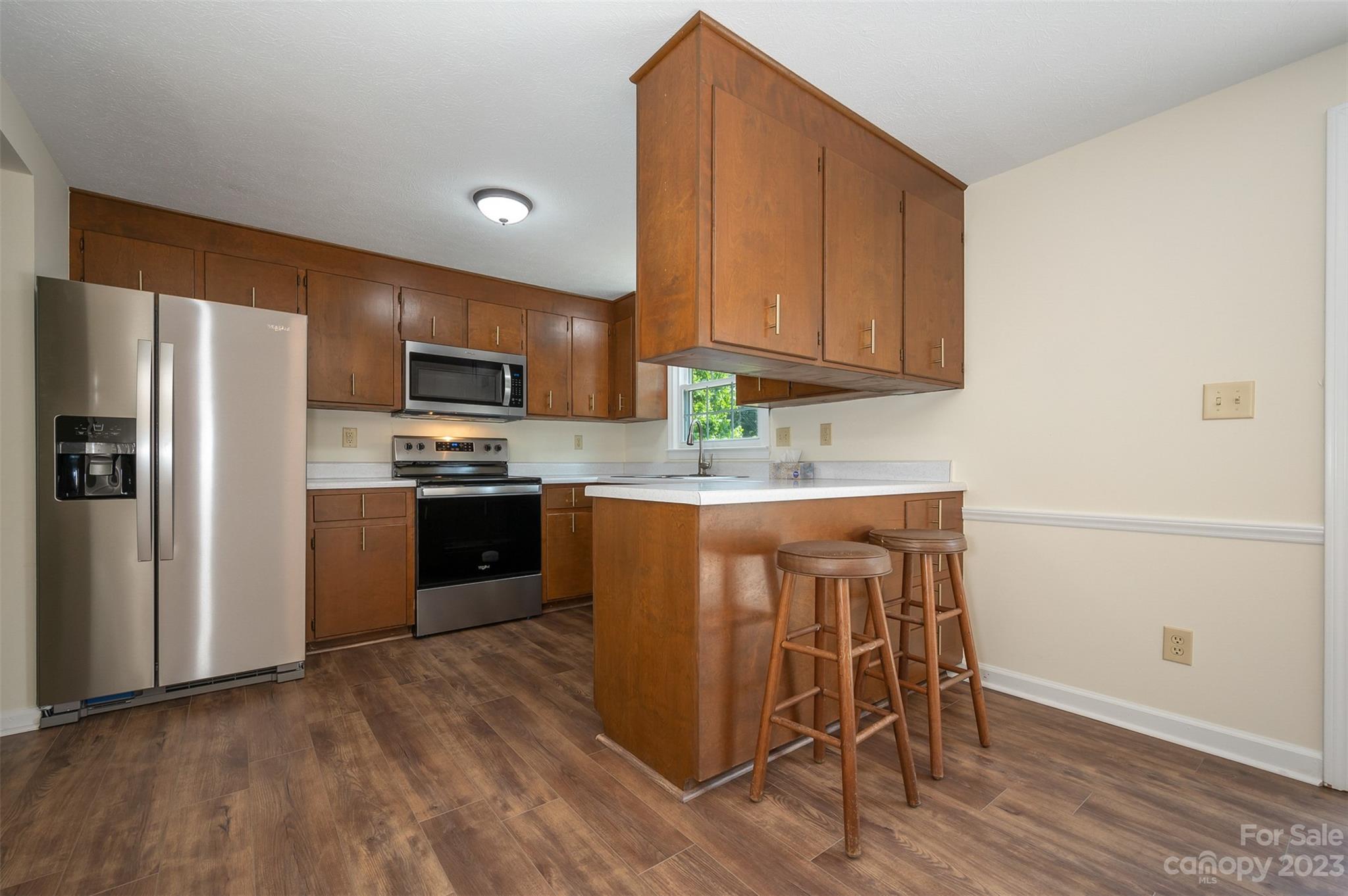 980 Brookside Camp Road Hendersonville, NC 28792 - Photo 11 of 47 a kitchen with kitchen island granite countertop wooden floors stainless steel appliances and a sink