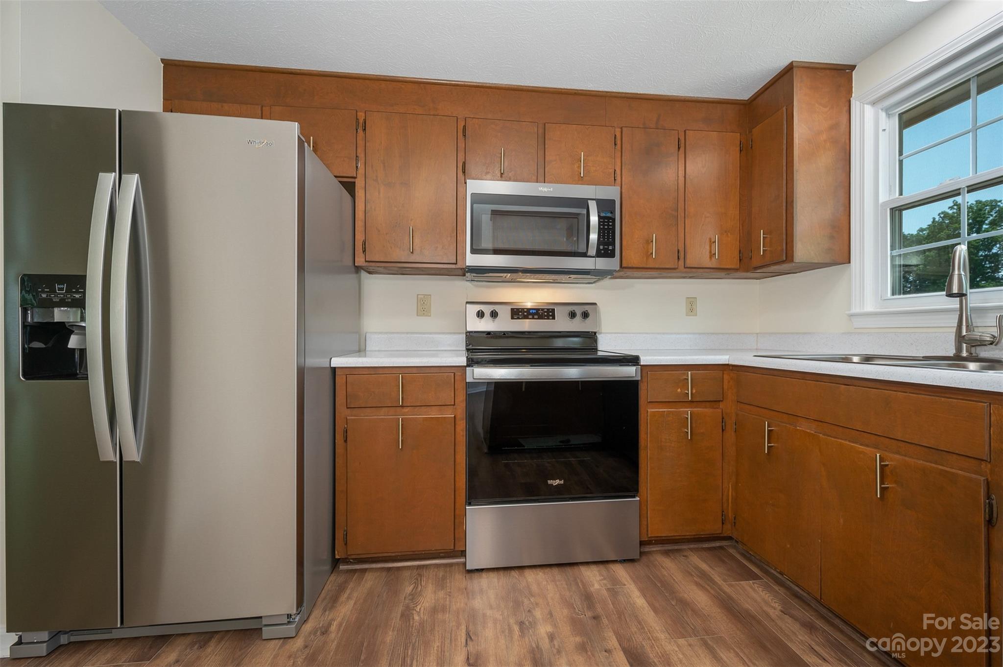 980 Brookside Camp Road Hendersonville, NC 28792 - Photo 17 of 47 a kitchen with stainless steel appliances a refrigerator stove and sink