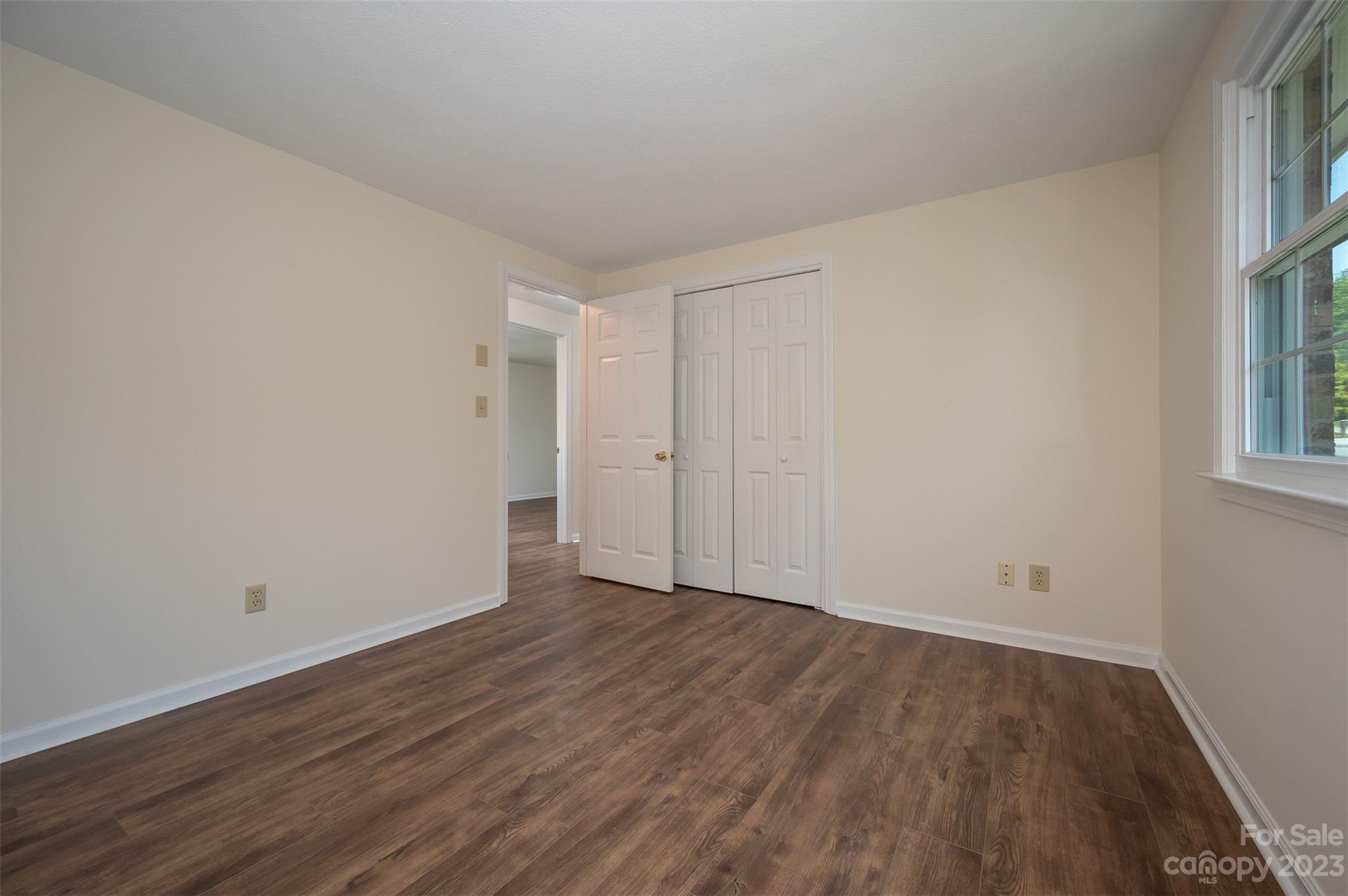 980 Brookside Camp Road Hendersonville, NC 28792 - Photo 21 of 47 a view of an empty room with wooden floor and a window