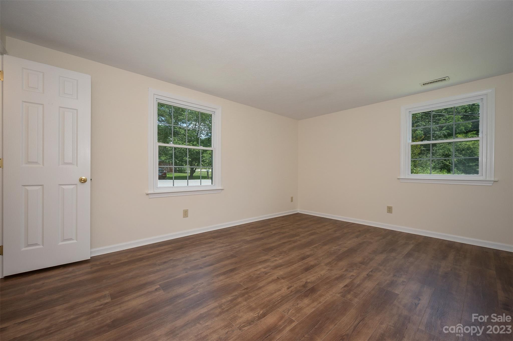 980 Brookside Camp Road Hendersonville, NC 28792 - Photo 24 of 47 an empty room with wooden floor and windows