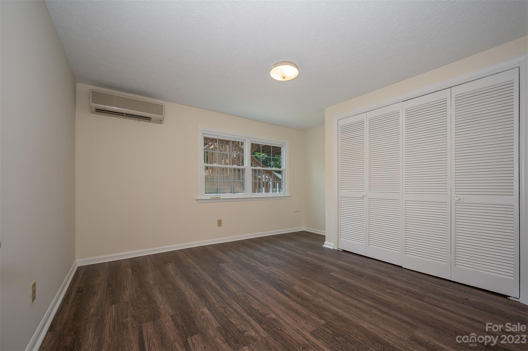 980 Brookside Camp Road Hendersonville, NC 28792 - Photo 33 of 47 an empty room with wooden floor and windows