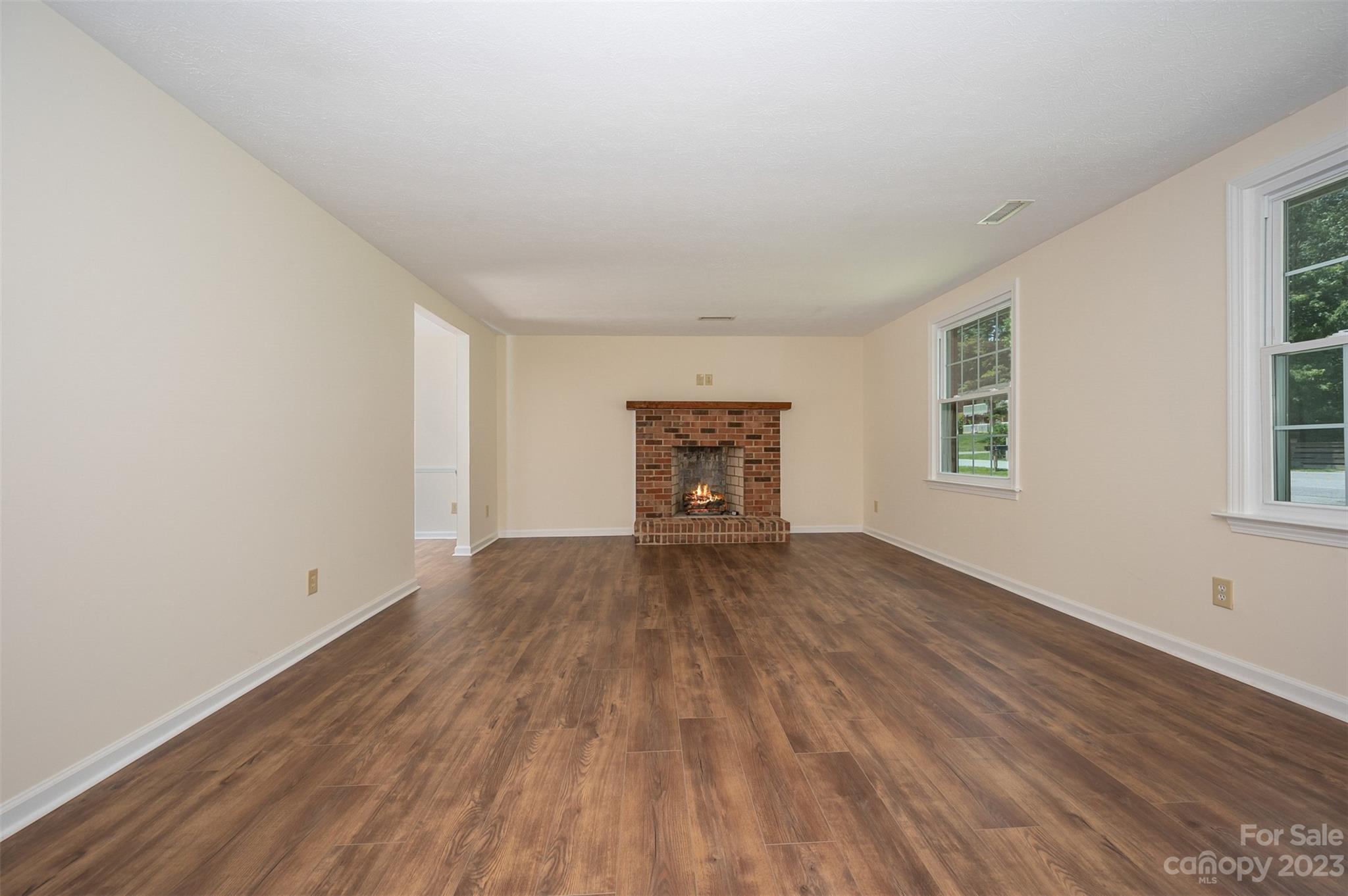980 Brookside Camp Road Hendersonville, NC 28792 - Photo 7 of 47 an empty room with wooden floor and windows
