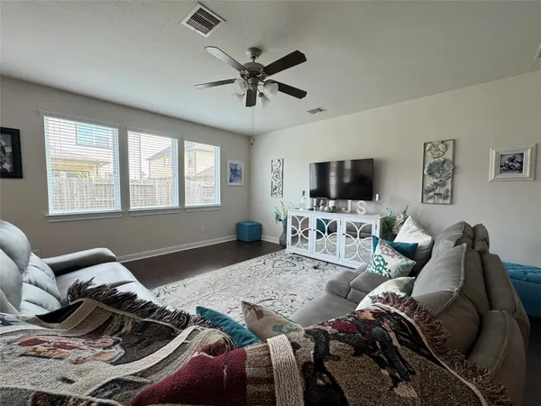 a living room with furniture tv and a window