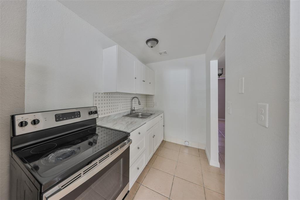 11708 Balm Riverview Road Riverview, FL 33569 - Photo 29 of 37 a kitchen with a stove and a white cabinet