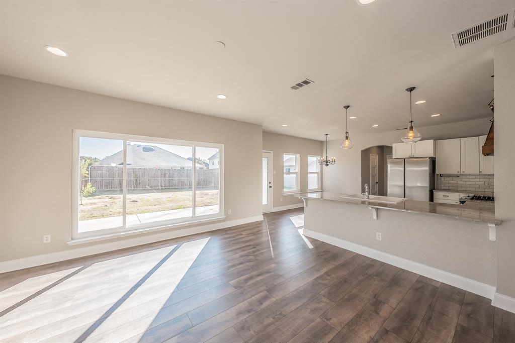 7305 Raintree Way Denton, TX 76210 - Photo 13 of 32 a view of an empty room with wooden floor and a window