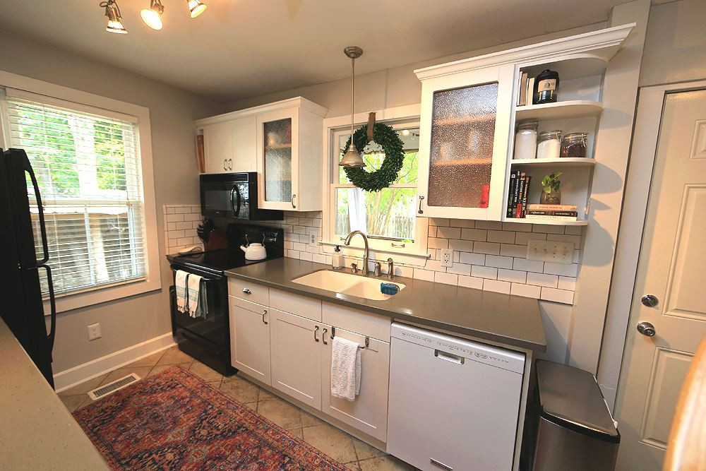1530 Carson Street Raleigh, NC 27608 - Photo 5 of 21 Updated kitchen features white cabinets, solid surface counters, new dishwasher and windows over looking the back yard. Kitchen