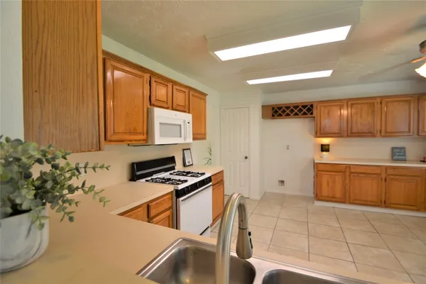 a kitchen with stainless steel appliances a sink a stove a microwave and cabinets