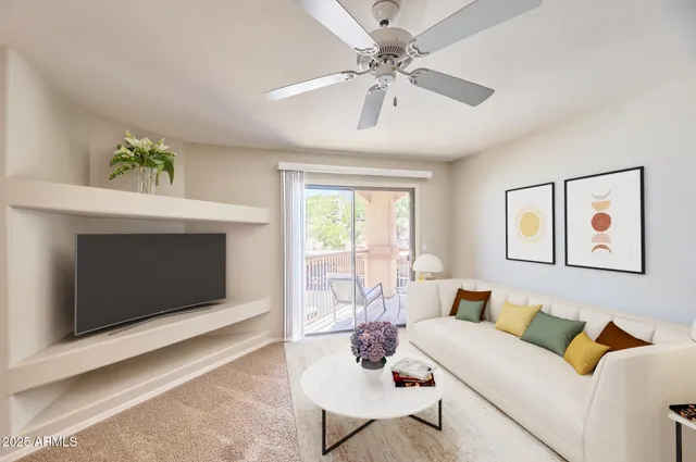 a living room with furniture a flat screen tv and a fireplace