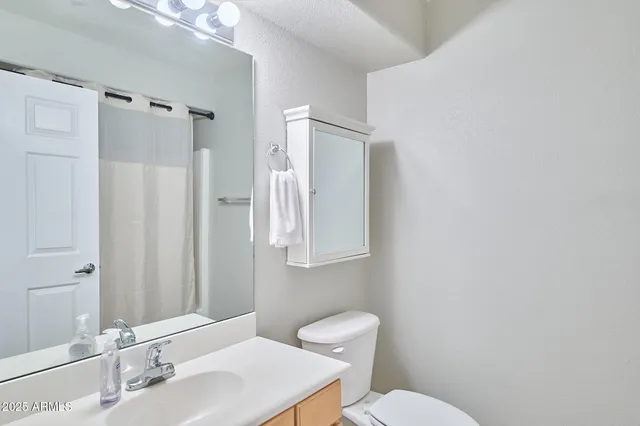 a bathroom with a toilet a sink and a mirror