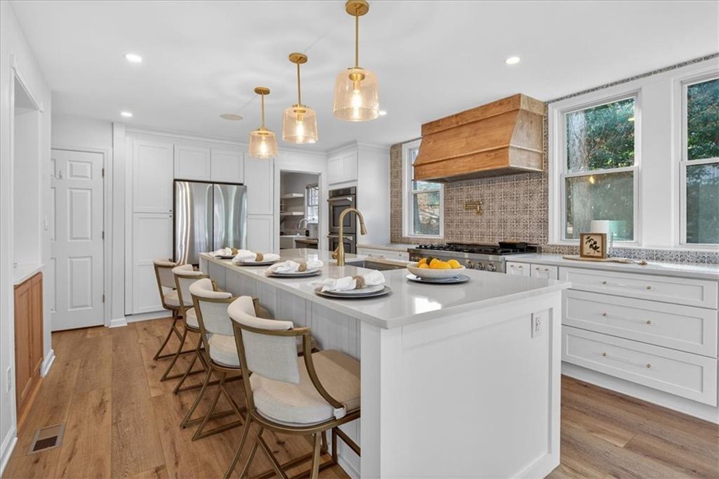 16145 Henderson Road Alpharetta, GA 30004 - Photo 2 of 61 a kitchen with a dining table chairs sink and wooden floor