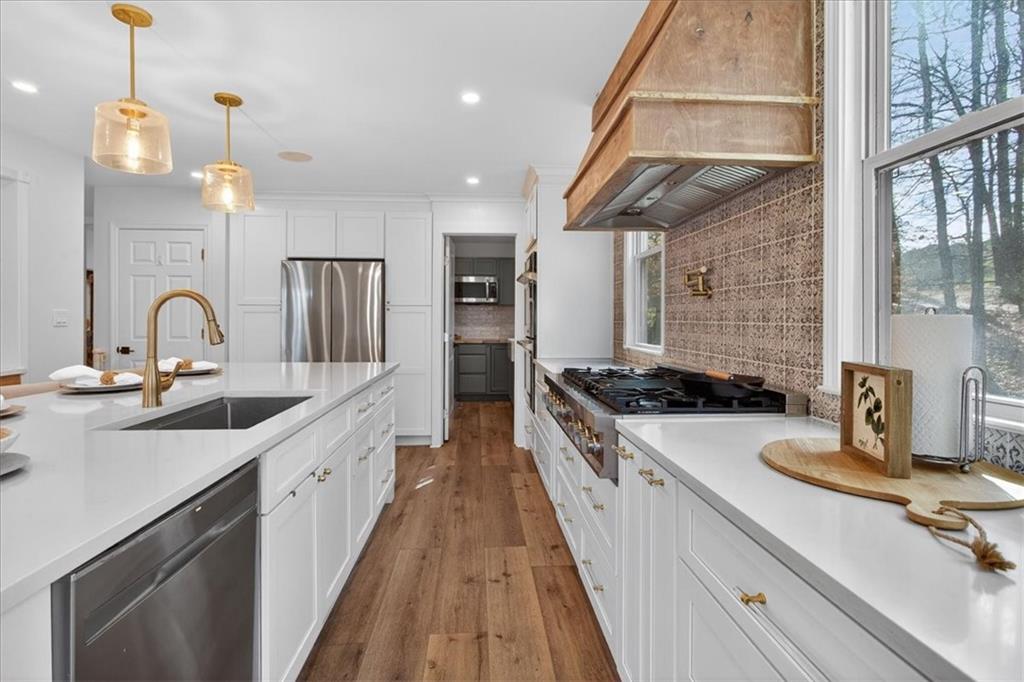 16145 Henderson Road Alpharetta, GA 30004 - Photo 21 of 61 a kitchen with sink a stove and chairs