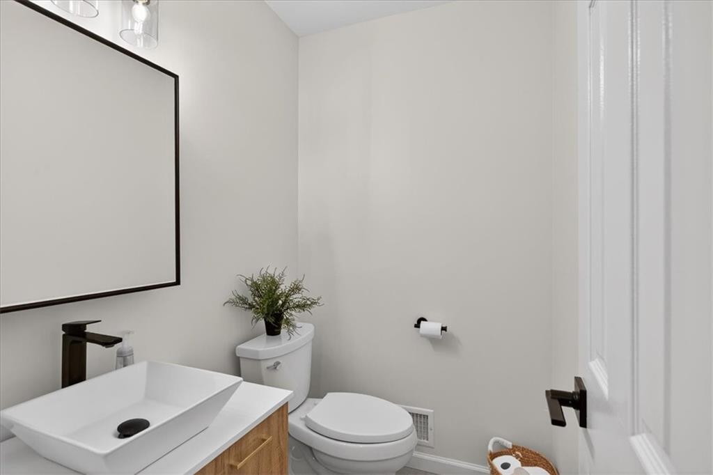 16145 Henderson Road Alpharetta, GA 30004 - Photo 27 of 61 a bathroom with a toilet a sink and a mirror