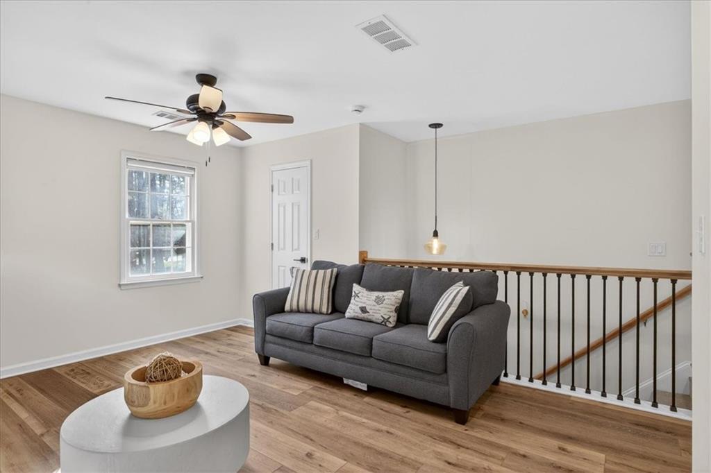 16145 Henderson Road Alpharetta, GA 30004 - Photo 28 of 61 a living room with furniture and a wooden floor