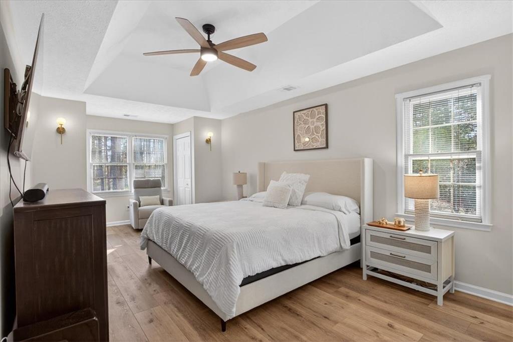 16145 Henderson Road Alpharetta, GA 30004 - Photo 30 of 61 a large bedroom with a bed and wooden floor