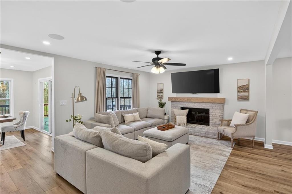 16145 Henderson Road Alpharetta, GA 30004 - Photo 3 of 61 a living room with furniture a fireplace and a flat screen tv