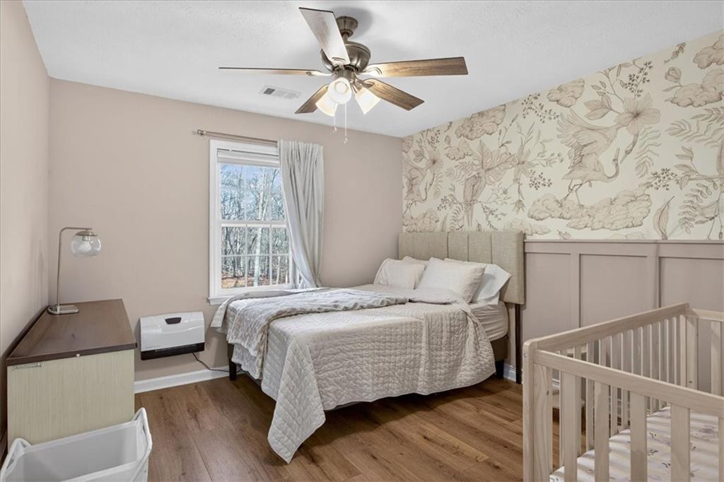 16145 Henderson Road Alpharetta, GA 30004 - Photo 39 of 61 a bedroom with a bed and wooden floor