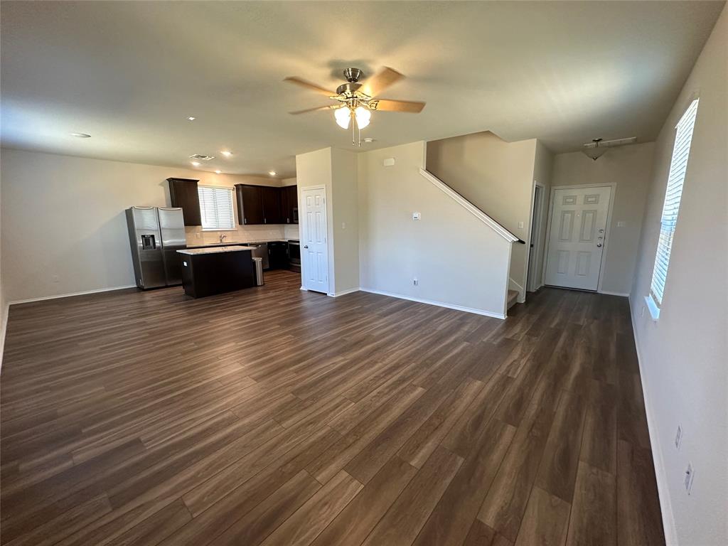 148 Prairie Falcon Way Leander, TX 78641 - Photo 2 of 19 an empty room with wooden floor and ceiling fan