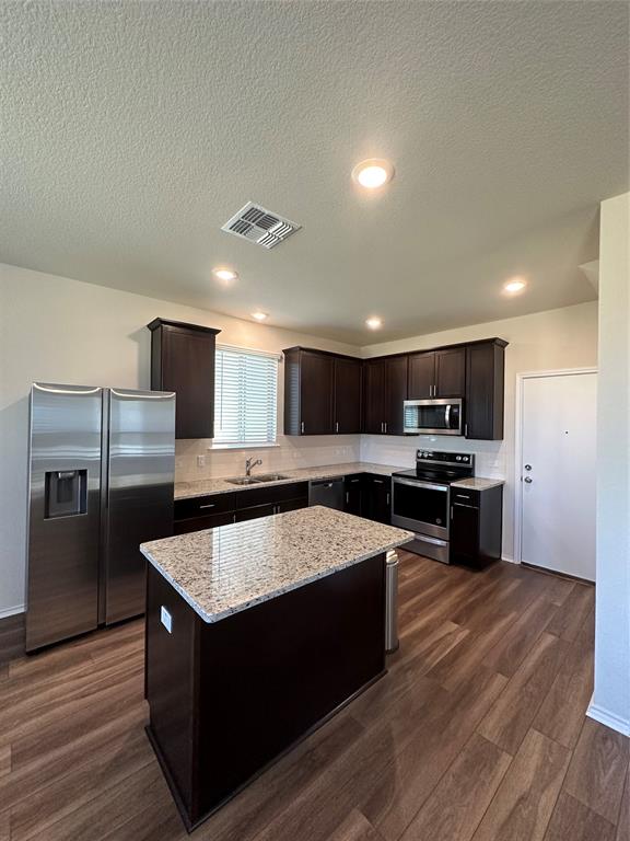 148 Prairie Falcon Way Leander, TX 78641 - Photo 5 of 19 a kitchen with stainless steel appliances wooden floor sink and stove