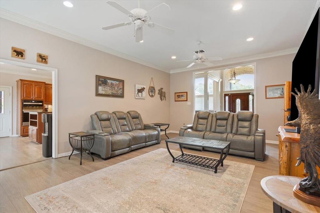111 Spring Creek Street Waco, TX 76705 - Photo 8 of 40 Recessed lighting, crown molding, wood-finish flooring, two ceiling fans, and a paneled entry door with sidelights
