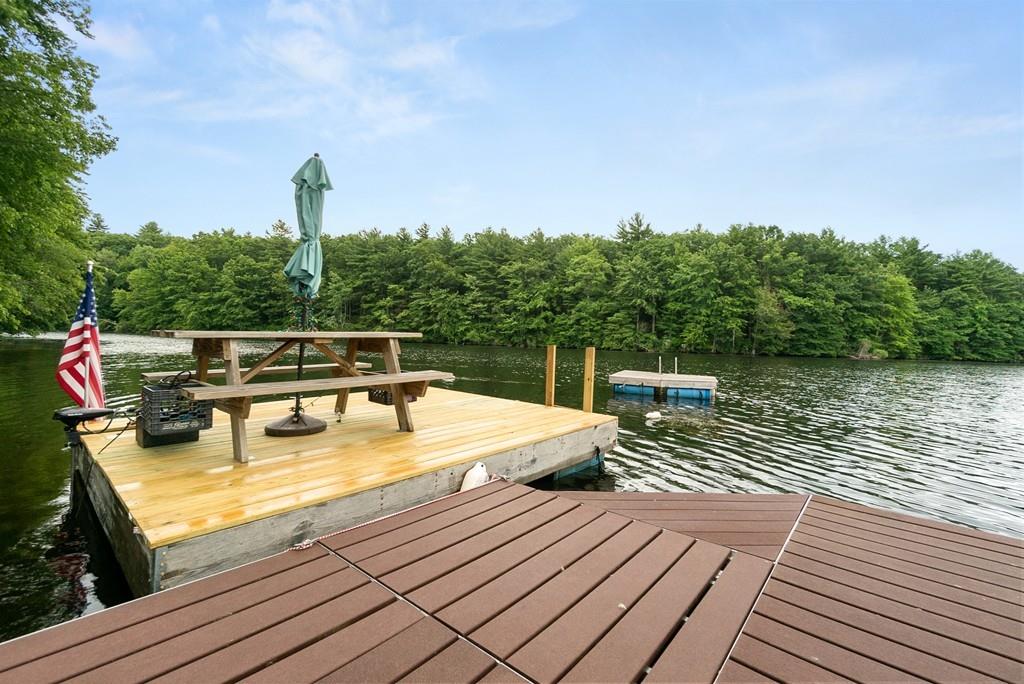 24 Ridge Trail Douglas, MA 01516 - Photo 31 of 36 a view of a roof deck with table and chairs a barbeque with wooden floor and fence