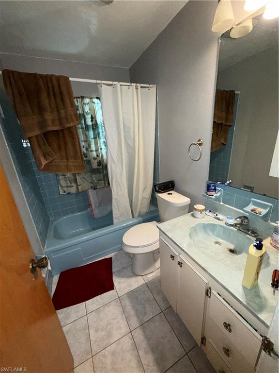 117 Robert Avenue Lehigh Acres, FL 33936 - Photo 13 of 20 Bathroom with shower / bath combination with curtain, vanity, and light tile patterned floors