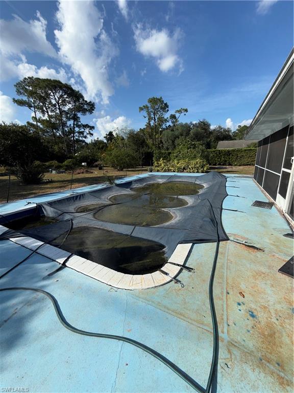 117 Robert Avenue Lehigh Acres, FL 33936 - Photo 16 of 20 Swimming pool featuring a patio and a sunroom