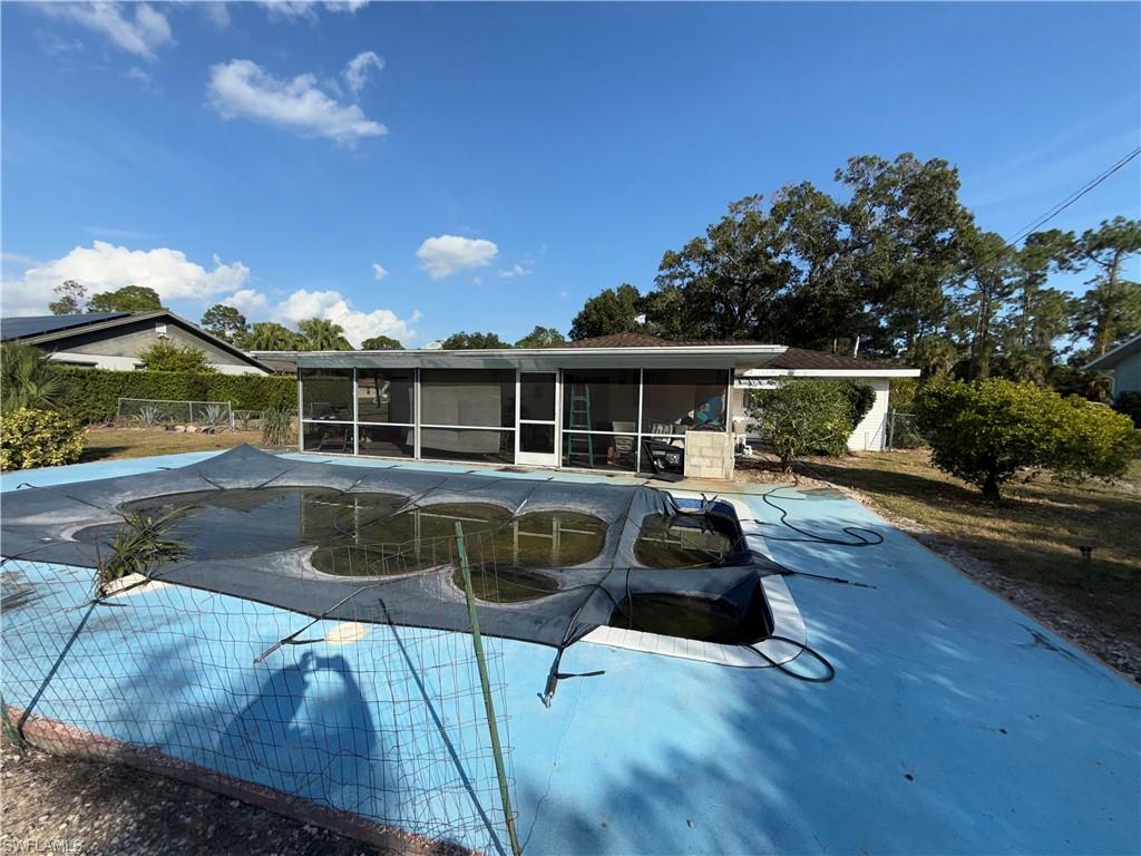 117 Robert Avenue Lehigh Acres, FL 33936 - Photo 18 of 20 View of pool featuring a covered pool, a sunroom, and a patio