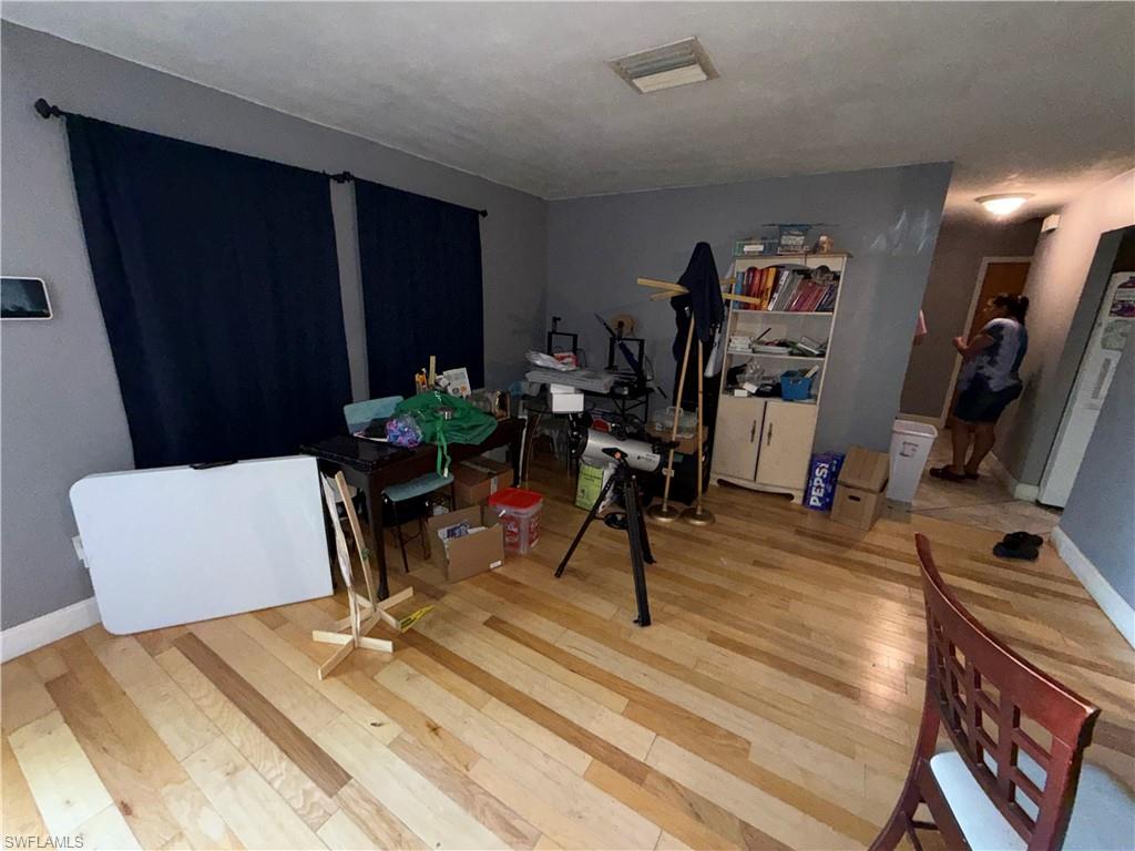 117 Robert Avenue Lehigh Acres, FL 33936 - Photo 2 of 20 Dining room featuring baseboards and light wood finished floors