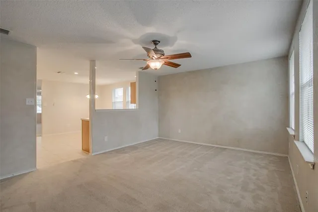 an empty room with fan and windows