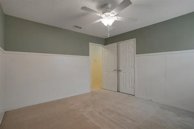 an empty room with a chandelier fan and a chandelier fan