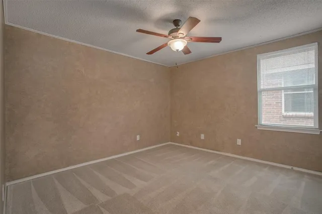 en empty room with windows and chandelier fan