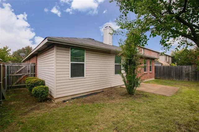 a backyard of a house with plants and tree
