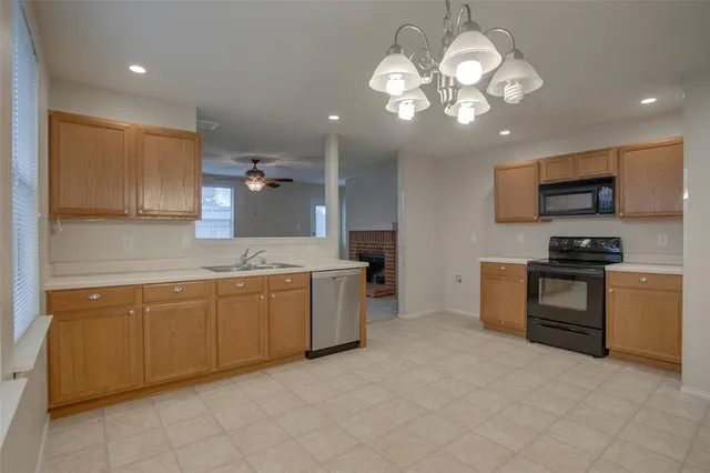 a large kitchen with cabinets a sink and stainless steel appliances