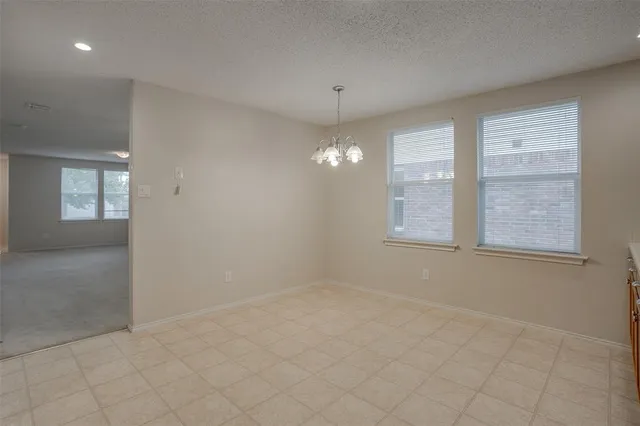 en empty room with windows and chandelier