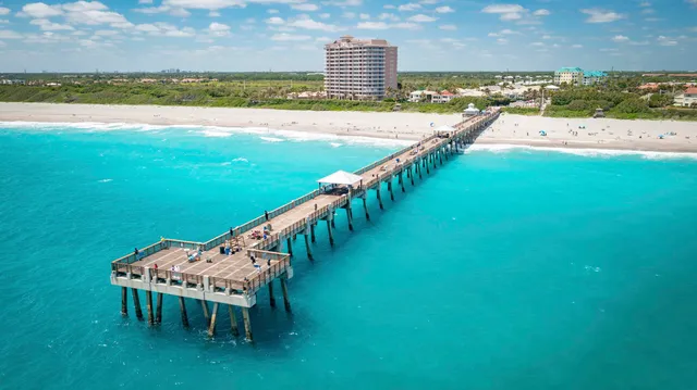 a living room with furniture kitchen view and a large window