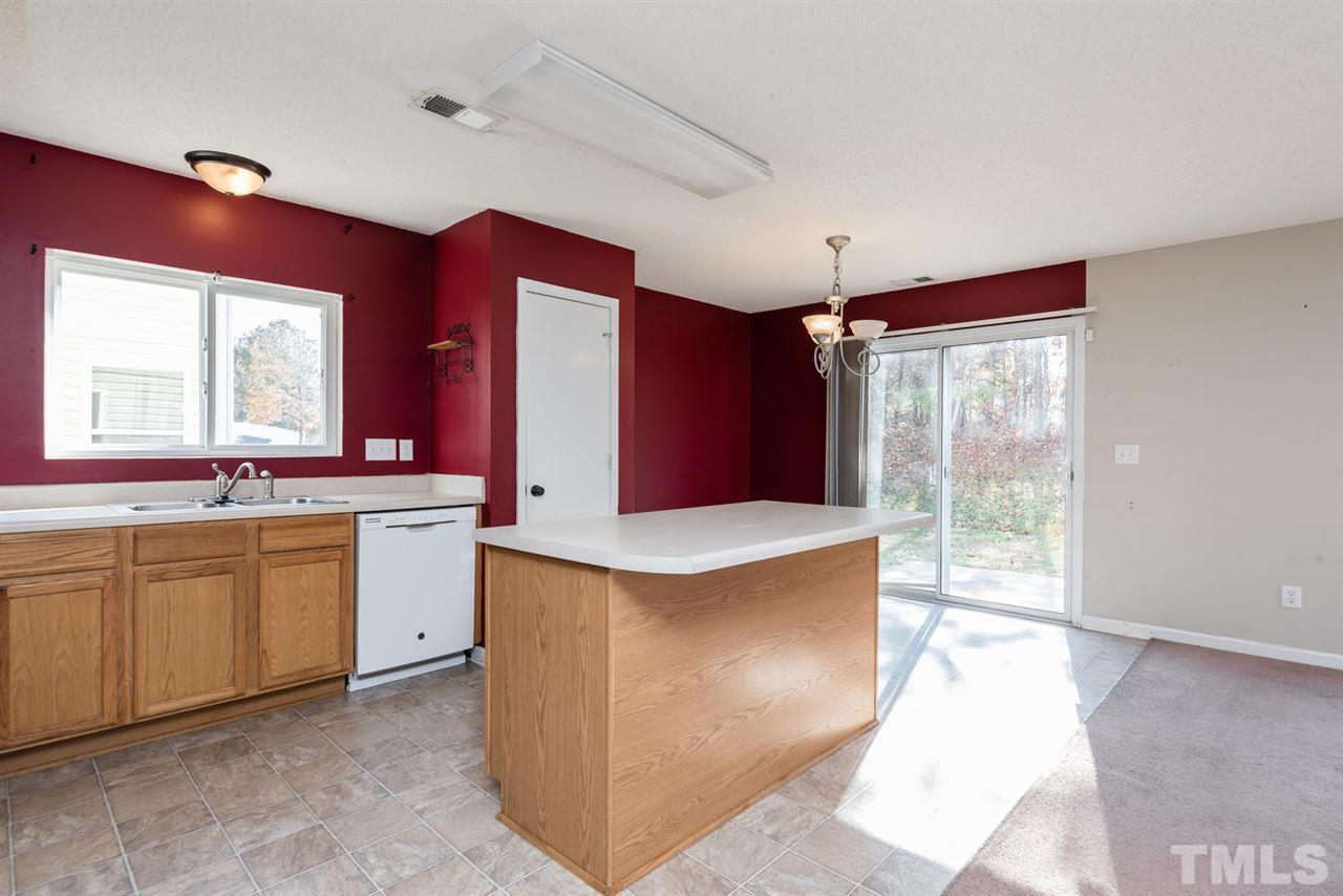 3670 Marshlane Way Raleigh, NC 27610 - Photo 11 of 22 a kitchen with granite countertop a sink stove top oven and cabinets