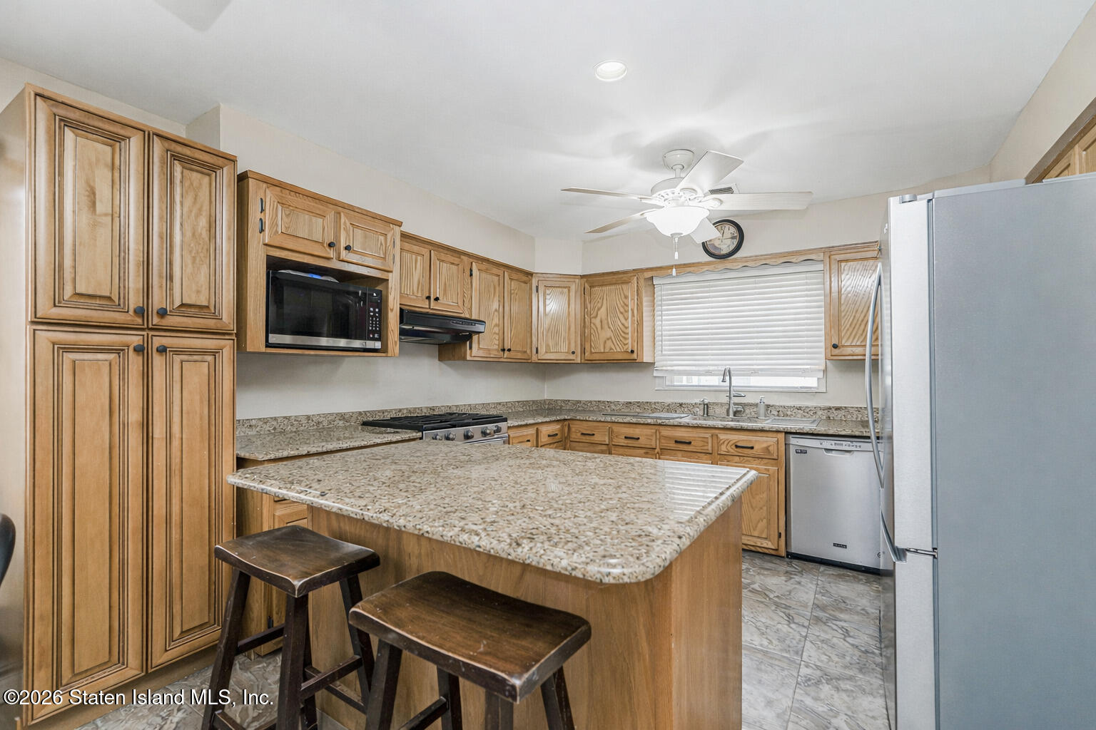 471 Main Street Staten Island, NY 10307 - Photo 13 of 39 a kitchen with granite countertop a table chairs microwave and refrigerator