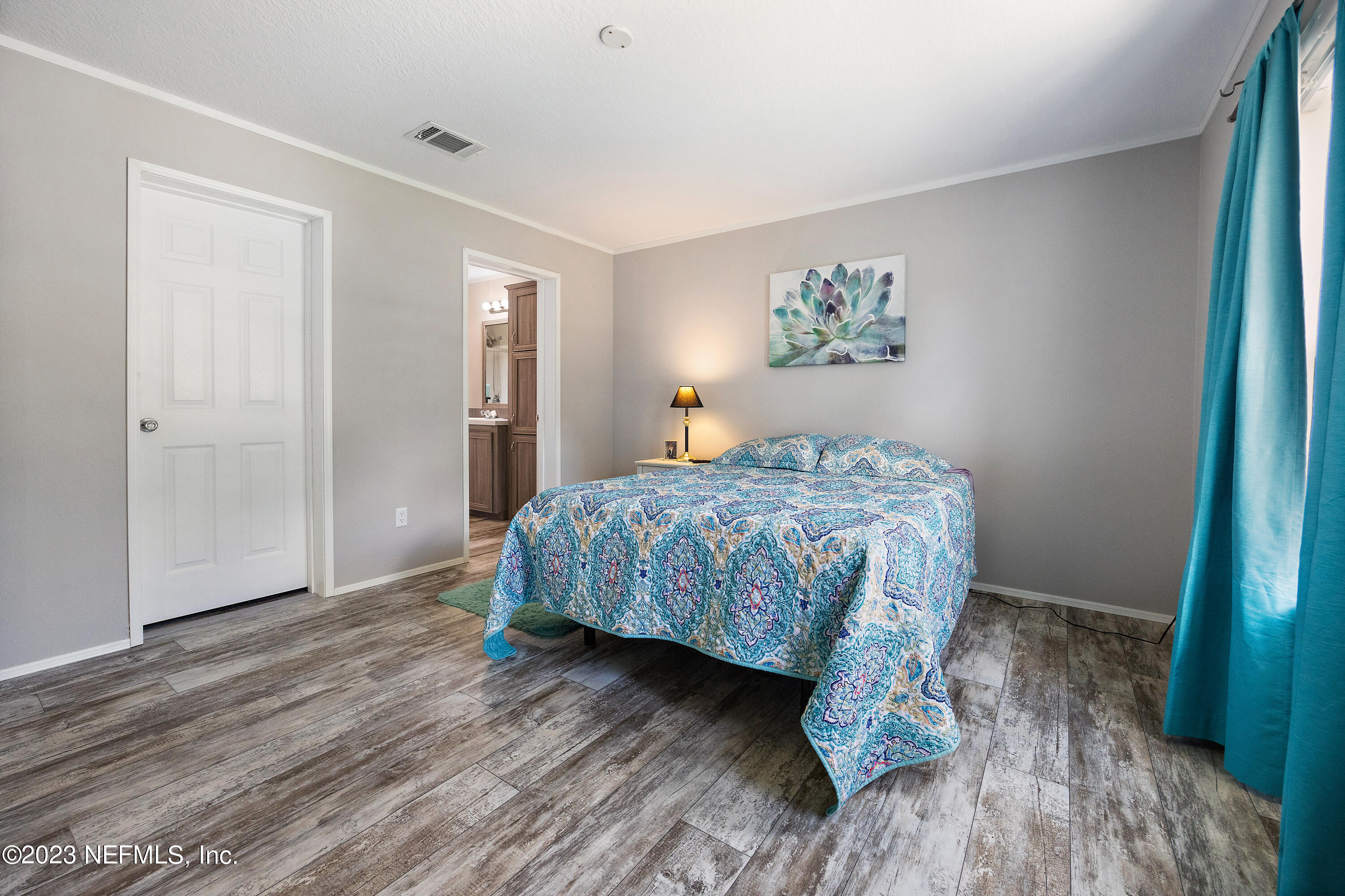 117 Riverside Avenue Satsuma, FL 32189 - Photo 11 of 24 a bedroom with a bed and a painting on the wall