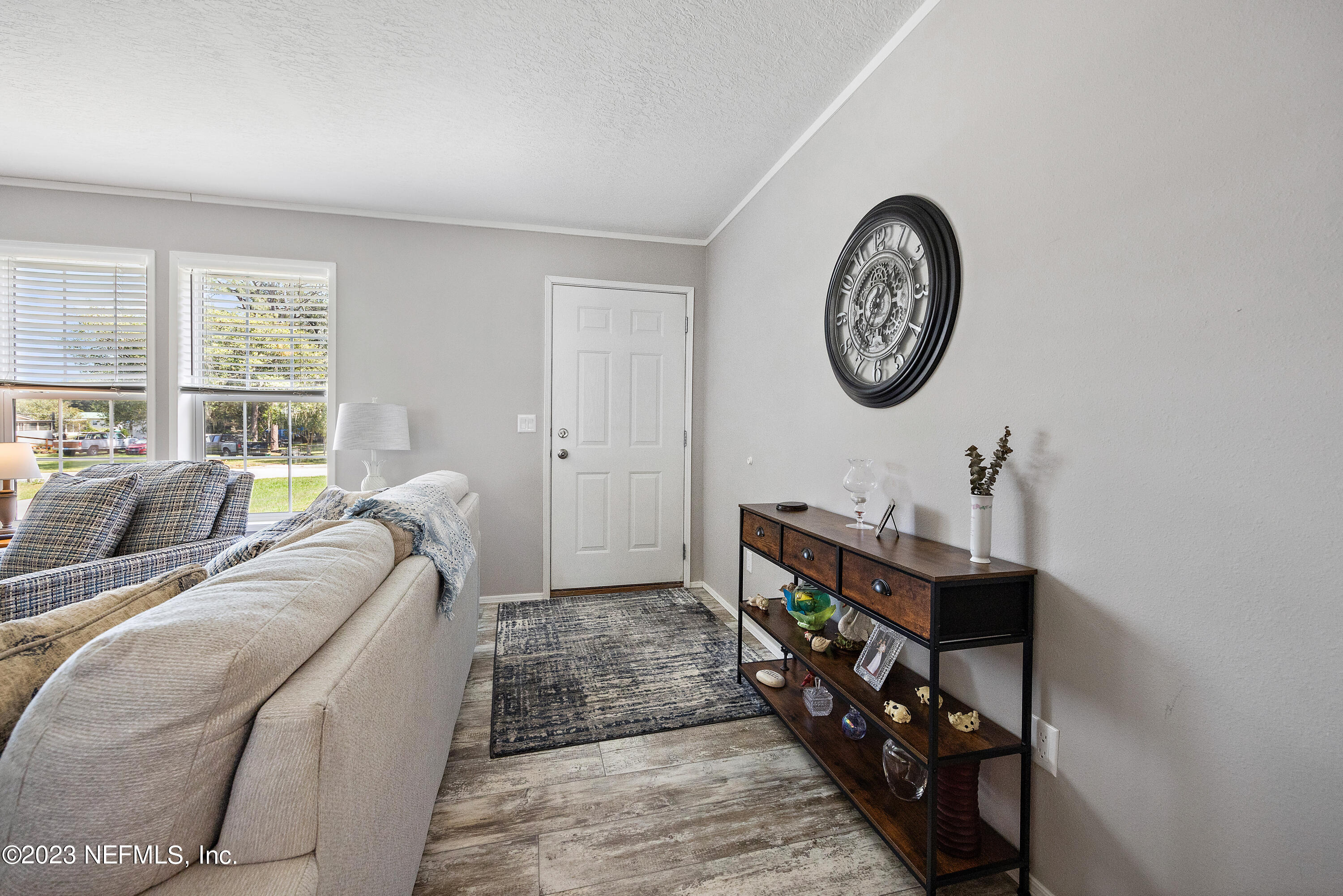 117 Riverside Avenue Satsuma, FL 32189 - Photo 17 of 24 a living room with furniture a clock and a window