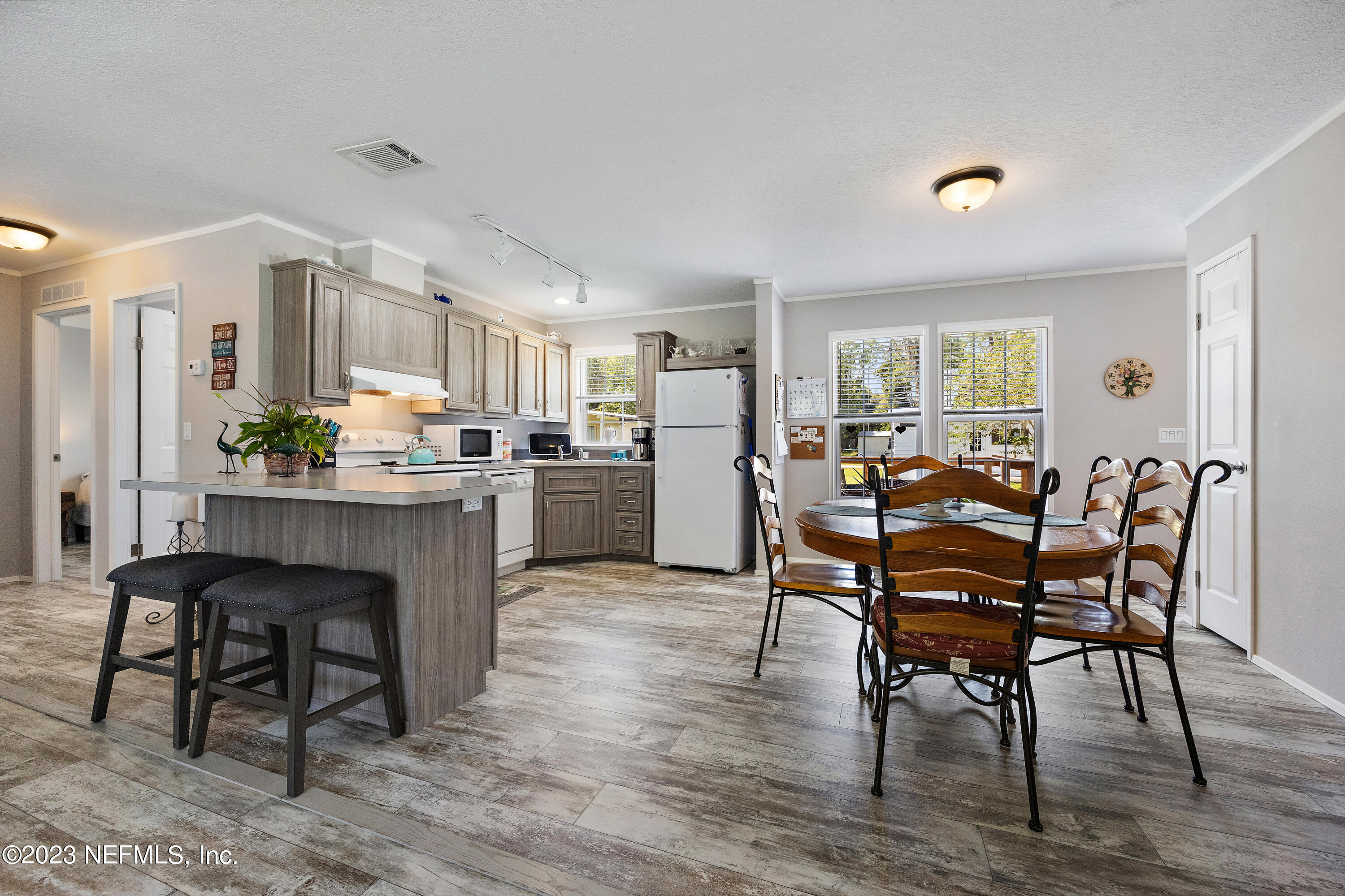 117 Riverside Avenue Satsuma, FL 32189 - Photo 2 of 24 a kitchen with a dining table chairs and refrigerator