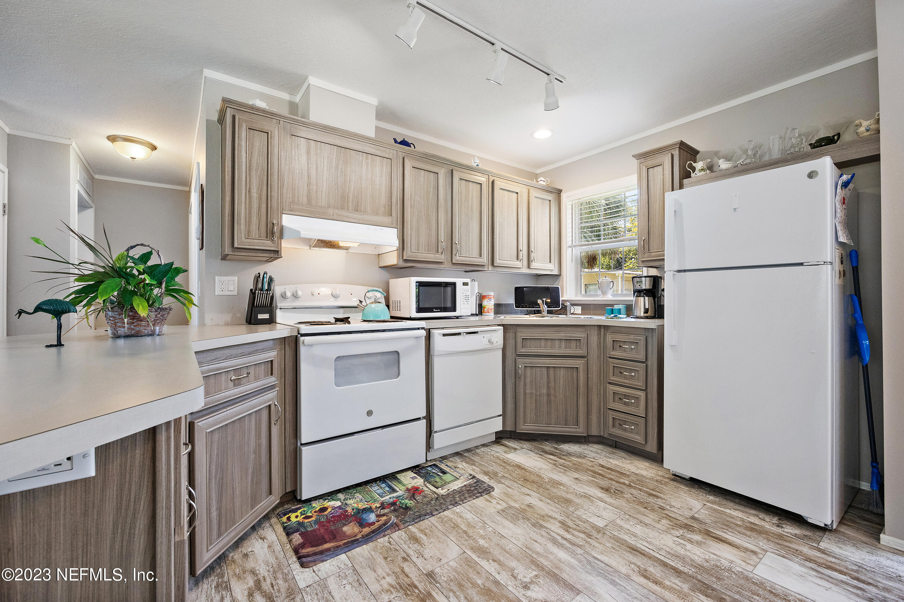 117 Riverside Avenue Satsuma, FL 32189 - Photo 7 of 24 a kitchen with white cabinets and white appliances