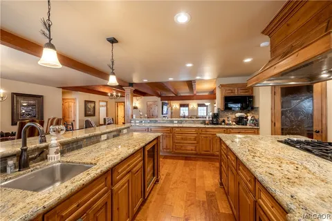 a large kitchen with granite countertop a large counter top appliances and cabinets