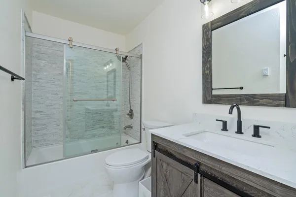 a bathroom with a sink a toilet and shower