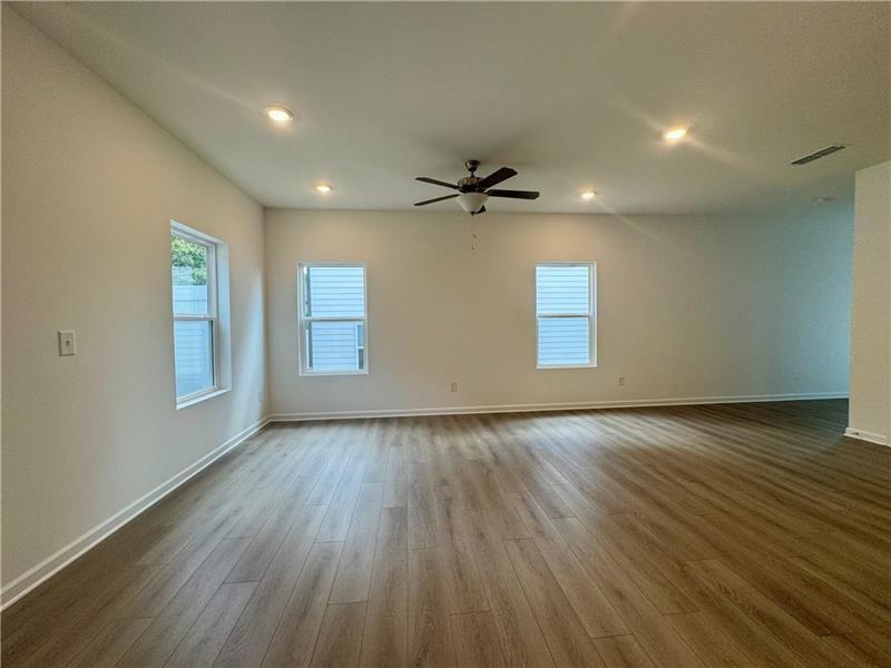 5305 Frontier Court Flowery Branch, GA 30542 - Photo 5 of 30 an empty room with wooden floor and windows