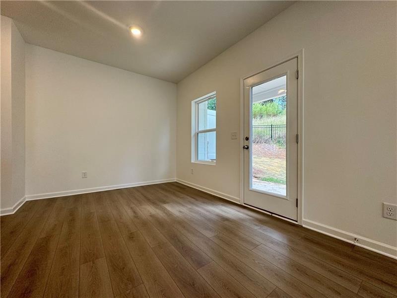 5305 Frontier Court Flowery Branch, GA 30542 - Photo 6 of 30 an empty room with wooden floor and windows