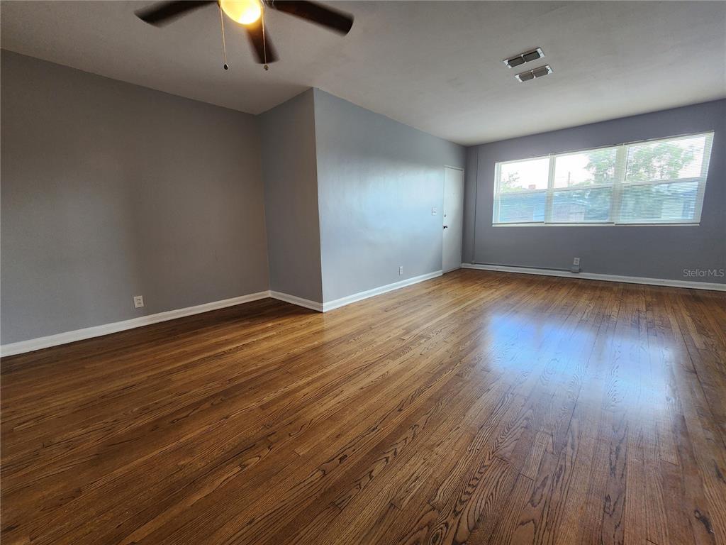 3148 Belden Street, Unit 3 Jacksonville, FL 32207 - Photo 3 of 4 an empty room with wooden floor chandelier fan and windows