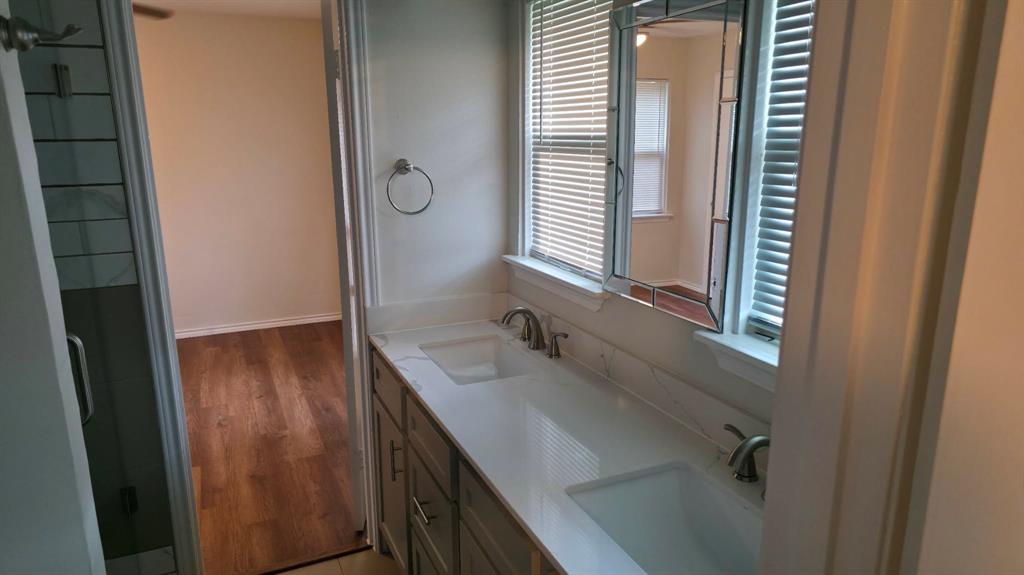 5722 Old Ox Road Dallas, TX 75241 - Photo 7 of 10 a bathroom with a sink a mirror and a shower
