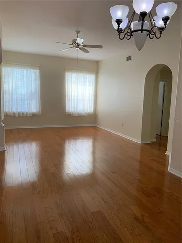 a view of a room with wooden floor and chandelier