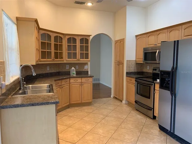 a kitchen with stainless steel appliances granite countertop a stove a sink and a refrigerator