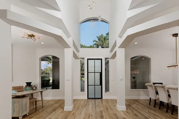 a view of a dining room with furniture a chandelier and wooden floor